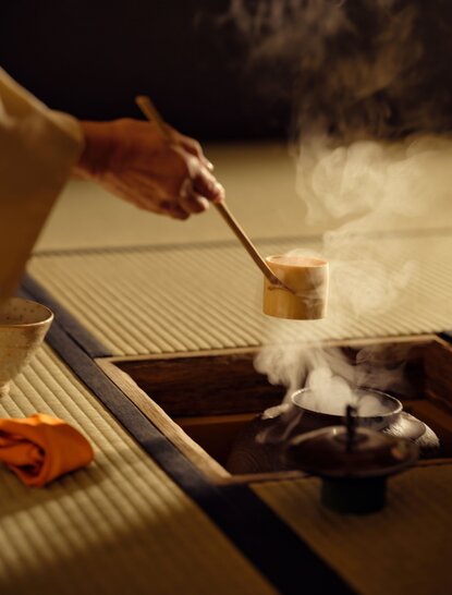 安缦京都度假村的茶道体验，一只手握毛笔蘸取茶粉准备点茶。