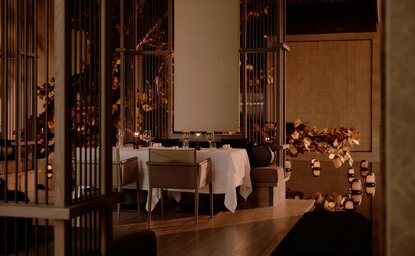 Candlelit dining venue at Aman Nai Lert Bangkok with festive decorations and warm ambient lighting.