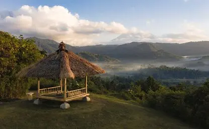 Taman Sari Bale pavilion overlooking misty valleys at sunrise, Amankila resort, Bali.