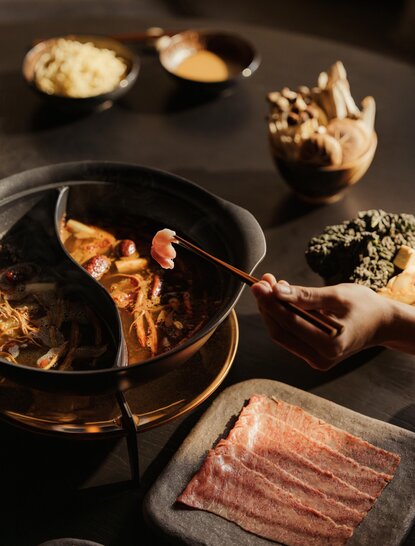 Aman Rosa Alpina dining experience featuring Alpine ingredients and charcuterie arranged on dark tableware.