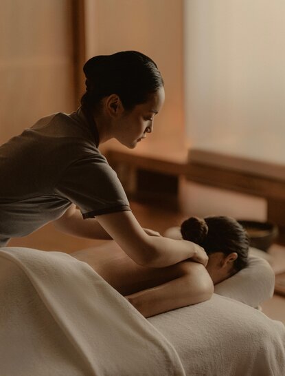Therapist administering a relaxing massage treatment at Aman Tokyo's spa wellness facility.