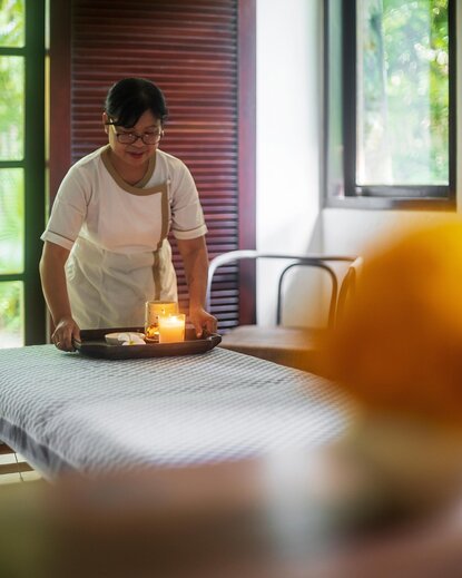 Therapist preparing wellness treatment room at Aman Villas at Nusa Dua, Indonesia.
