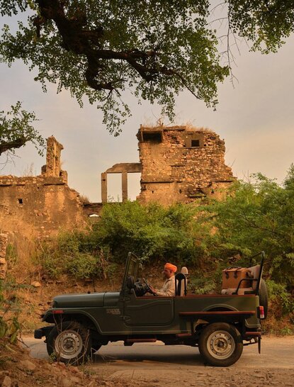 Jeep parked beside historic ruins at Amanbagh, India, during a Cow Dust Village Tour.