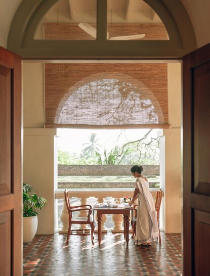 Veranda at Amangalla with arched doorway opening onto dining area overlooking gardens.