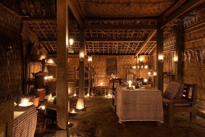 Candlelit dining room at Amanjiwo with wooden latticed ceiling and hanging lanterns.