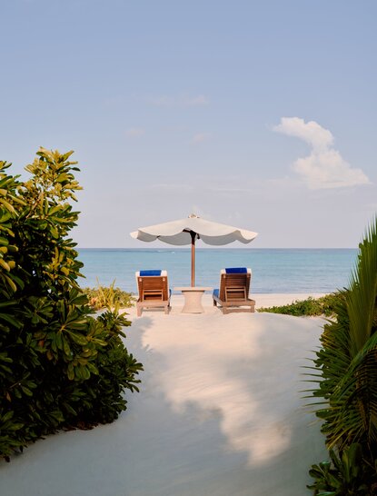 Grand Beach Pool Casita at Amanpulo, Philippines, with loungers and umbrella facing the sea.