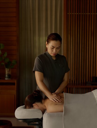 Therapist performing a relaxing leg massage treatment at Amanyara's wellness spa.