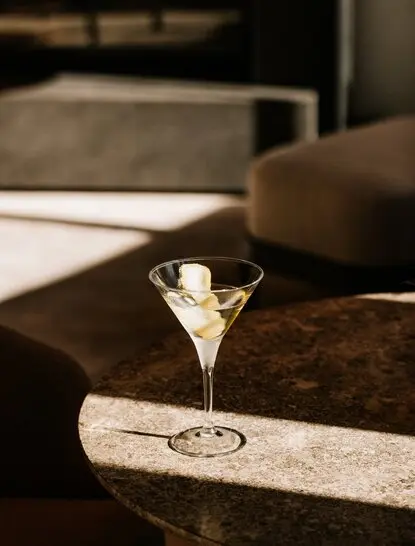 Martini cocktail on marble table at Il Salotto bar, Aman Rosa Alpina.
