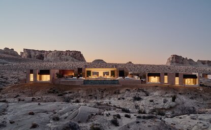 Six-bedroom villa at Amangiri illuminated at dusk, nestled in desert landscape.