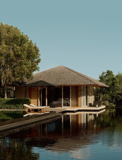 Villa with thatched roof reflected in still water at Amanyara, Turks & Caicos.