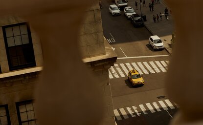 Vista aérea de rua em Nova York com faixas de pedestres e edifícios, Aman New York.