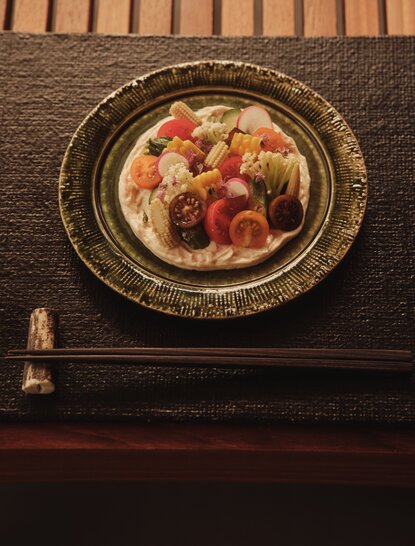 Terrace at Aman New York hotel with plated dessert featuring fresh berries and edible flowers.