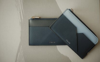 Aman Tokyo retail fragment case displaying dark blue and black geometric packaging on white surface.