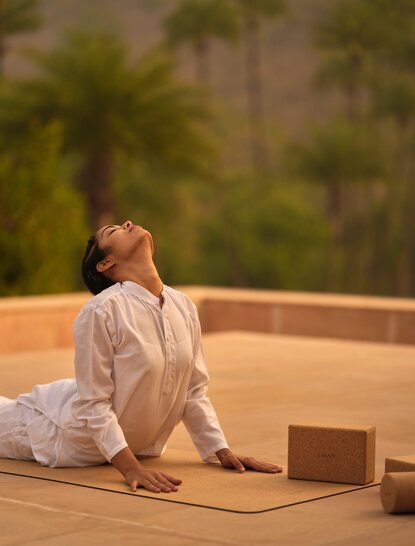 Woman practising yoga on terrace at Amanbagh, India spa and wellness resort.
