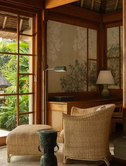 Single-storey pavilion bedroom at Amandari, Indonesia, with wooden-framed windows overlooking gardens and woven furnishings.