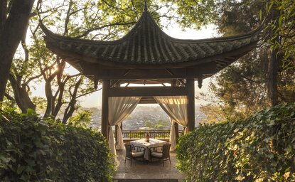 大研安缦度假村的中式亭台，飞檐翘角，框景远处建筑。