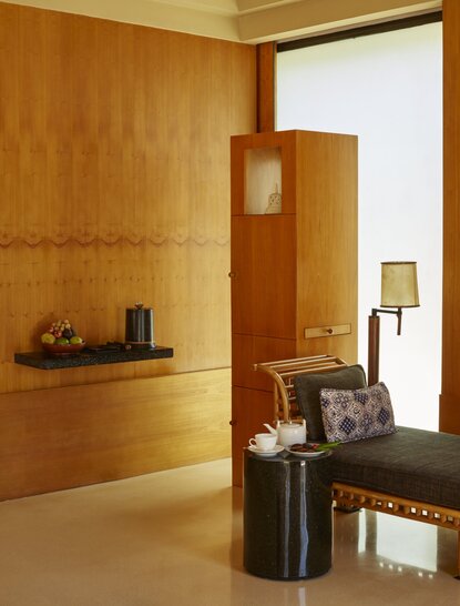 Pavillon de séjour aux murs en bois clair et mobilier minimaliste à Amanjiwo, resort en Indonésie.