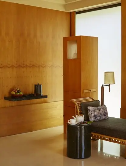 Amanjiwo resort pavilion living area with warm timber walls and minimalist furnishings.