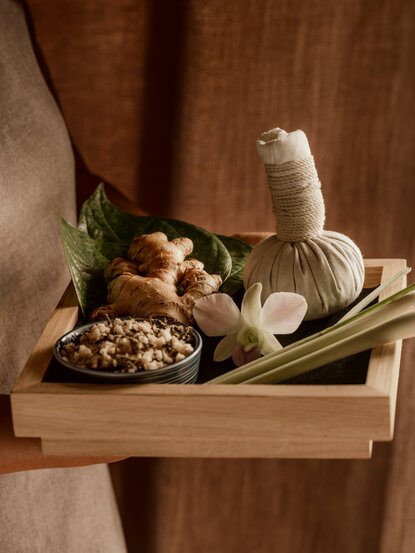 Spa essentials arranged on wooden tray at Amanoi, featuring herbal ingredients and natural wellness products.