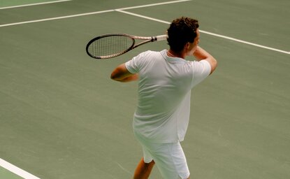 Model playing tennis on the court at Amanera resort, Thailand.
