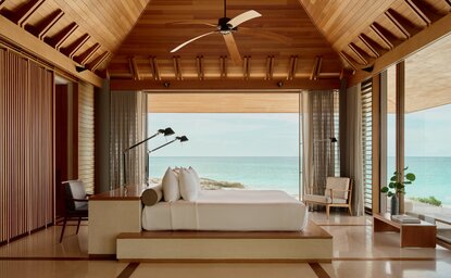 Villa 33 spa bath at Amanyara with ocean views through open wooden doors.