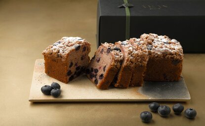 Sliced blueberry pound cake dusted with icing sugar at Aman Kyoto, garnished with fresh blueberries.
