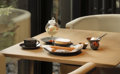 Soufflé au fromage servi à Aman Kyoto, avec thé et pâtisseries sur table en bois naturel.