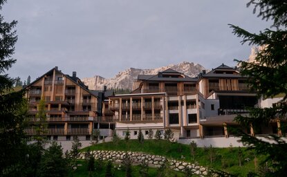 Exterior view of Aman Rosa Alpina property in the Italian Alps, surrounded by alpine vegetation.