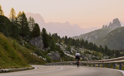 Aman Rosa Alpina resort nestled in the Dolomites with dramatic mountain peaks at sunset, Italy.