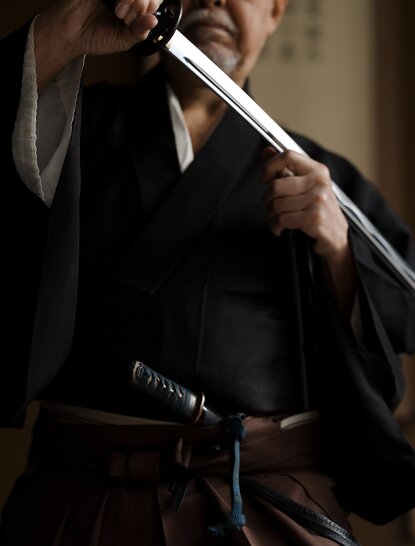Maître iaïdo en tenue traditionnelle tenant un katana à Aman Tokyo.