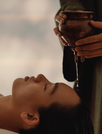 Woman receiving water ritual treatment at Amanemu spa, Japan.