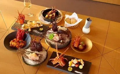 Amanemu lobster menu featuring an array of Japanese dishes arranged on a wooden table.