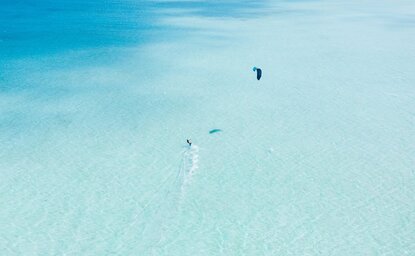 Kitesurfeur dans le lagon turquoise d'Amanpulo, une station balnéaire aux Philippines.