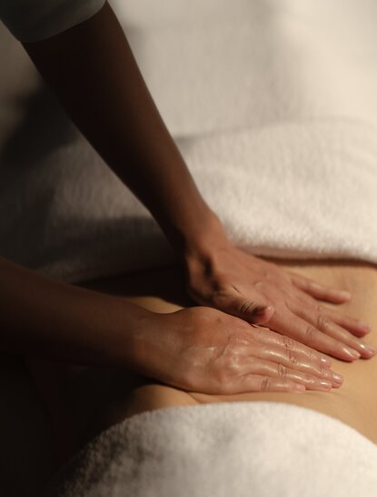 Therapist's hands applying oil massage treatment at Amanpuri, Thailand.
