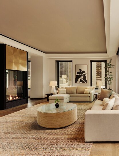 Two-bedroom home at Aman New York with circular stone table, cream seating, and pool access.