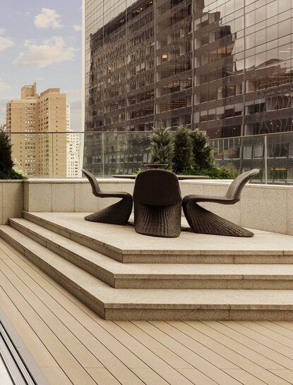 Two-bedroom home terrace with striped wooden decking overlooking New York City skyline at Aman New York.