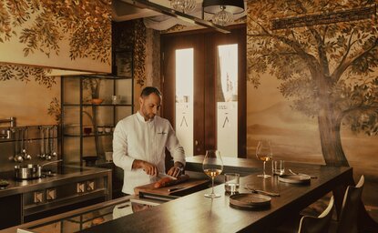 Executive Chef Matteo Panfilio preparing a dish at the kitchen table in アマン ヴェニス's Palazzo Kitchen.