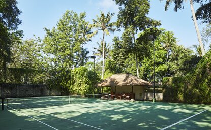 Tennis court at Amandari resort surrounded by lush tropical vegetation, Bali, Indonesia.