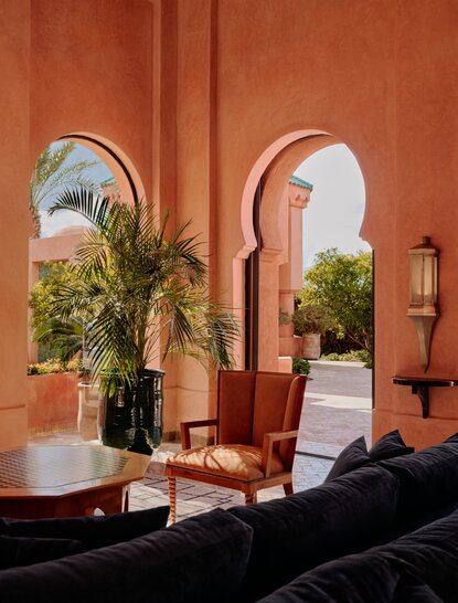 Moroccan villa interior at Amanjena with arched doorways framing gardens and terracotta walls.