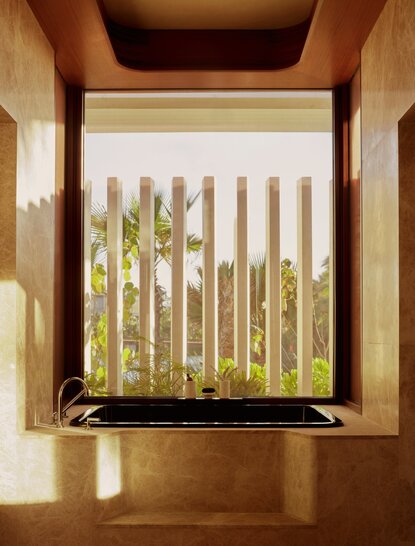 Wooden window frame overlooking palm trees at Amanvari, Mexico beachfront casita.