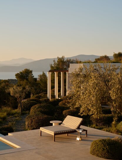 Piscina de una villa en Amanzoe con vistas al mar Egeo y columnas antiguas, Grecia.