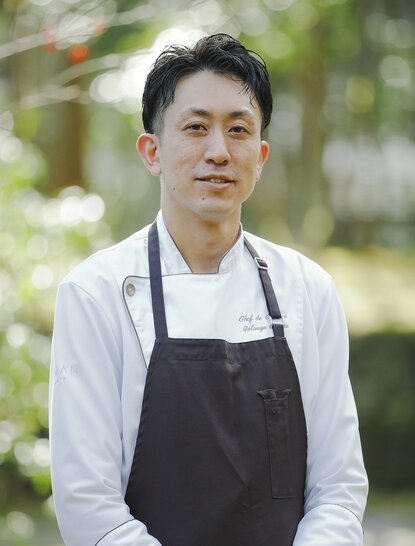 Tatsuya Ozawa, executive sous-chef at Aman Kyoto resort, photographed outdoors wearing chef's apron.