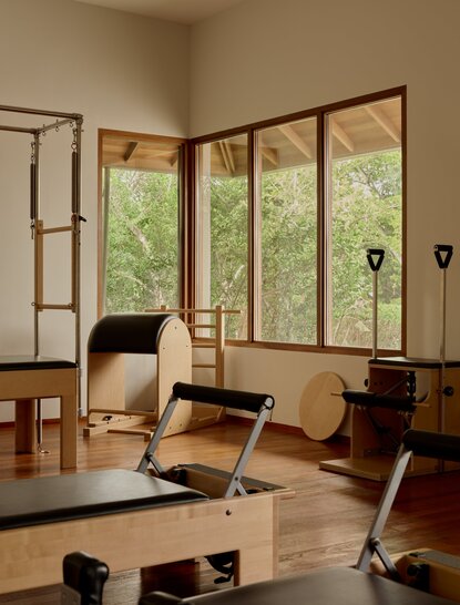 Pilates studio at Amanyara with wooden exercise equipment, natural light from large windows, and minimal décor.