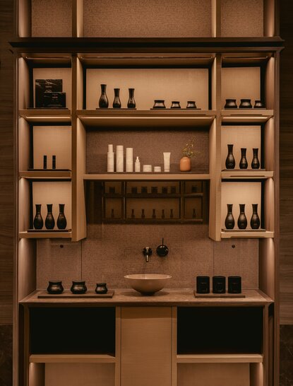 Aman Essentials product display shelf at Aman Nai Lert Bangkok, featuring curated skincare and wellness bottles.