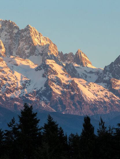 Snow-capped peaks of Jade Dragon Snow Mountain at Amandayan, bathed in golden morning light.