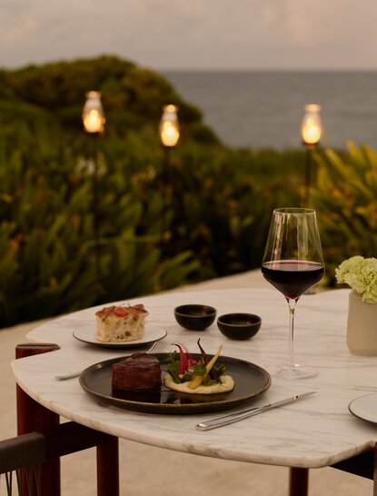 Private dining table at Amanera overlooking Dominican Republic coastline at dusk.
