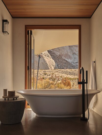 Freestanding bathtub positioned at a window overlooking desert landscape at Amangiri.