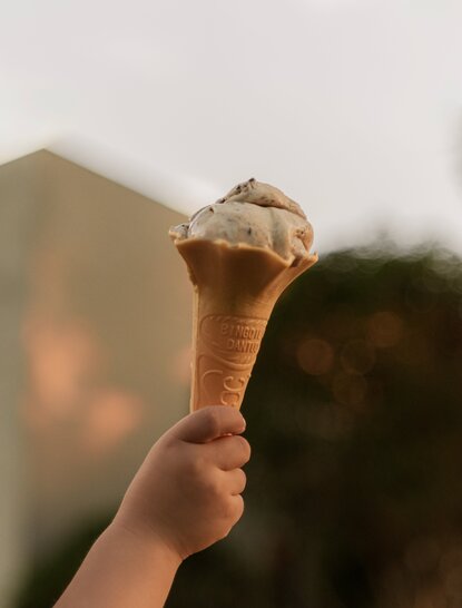 Hand holding ice cream cone at Amanyangyun, China.