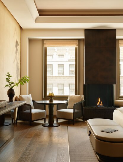 Premier Suite at Aman New York with fireplace, seating area and city views.