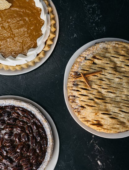 Thanksgiving pies at Aman New York: berry, pecan and pumpkin varieties displayed from above.